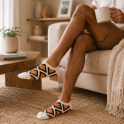 White, Orange and Black patterned low-cut socks worn in a relaxed lifestyle setting.
